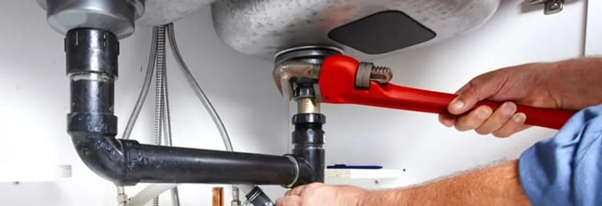 Garbage disposal repair technician tightening the sink drain and disposal connection in New Orleans, LA